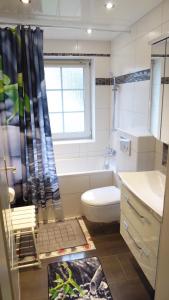 Un baño con inodoro, bañera y lavabo. en Blumen Apartment, en Hamburgo 26 fotos más