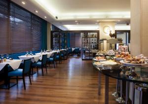 a restaurant with tables and chairs and a buffet at LH Hotel Sirio Venice in Mestre