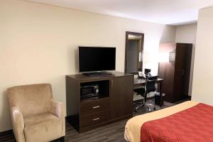 a hotel room with a bed and a television and a desk at Econo Lodge City Center in Portland