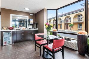 a dining room with a table and red chairs at Econo Lodge in Gainesville