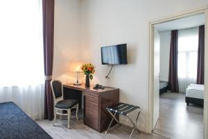 Pokój hotelowy z biurkiem i telewizorem w obiekcie Hotel Assenzio Prague w Pradze
