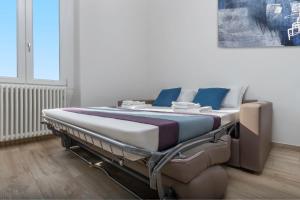 łóżko szpitalne w pokoju z biało-niebieskimi poduszkami w obiekcie Casa da Suite Hora w Mediolanie