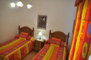 ビジャヌエバ・デ・ロス・インファンテスにあるCasa Rural Los Galanesのベッドルーム1室(ツインベッド2台、ナイトスタンド付)