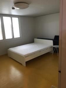 a bed in a room with two windows at Sam Apartment in Goyang