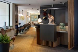 a man standing at a counter in a restaurant at Apparthotel 37 Lodge - Courbevoie La Défense in Courbevoie