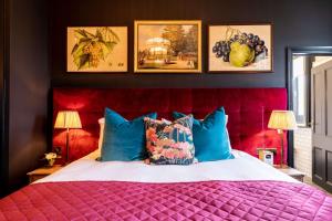 a bedroom with a large bed with a red head board at The Park Hotel in Teddington
