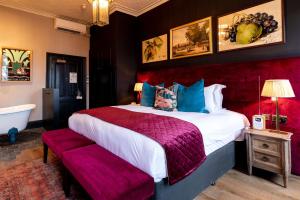 a bedroom with a large bed and a bath tub at The Park Hotel in Teddington