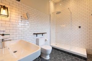 a bathroom with a toilet and a tub and a sink at The Park Hotel in Teddington