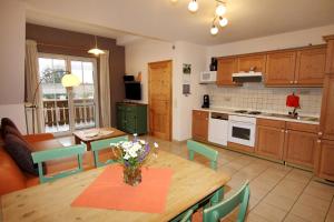 eine Küche und ein Esszimmer mit einem Holztisch und Stühlen in der Unterkunft Ferienwohnungen Sonnengarten in Gunzenhausen