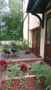 a patio with potted plants and a table and chairs at Pension Am Holzgraben in Lübbenau