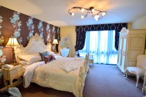 a bedroom with a large bed and a large window at Angmering Manor Hotel in Angmering