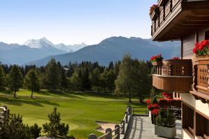 Blick auf einen Golfplatz mit Bergen im Hintergrund in der Unterkunft Guarda Golf Hotel & Residences in Crans-Montana