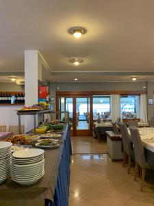 una sala da pranzo con tavolo e piatti di Hotel Ambra a Lignano Sabbiadoro