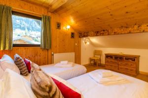 a bedroom with two beds and a window at Les Clochettes in Megève