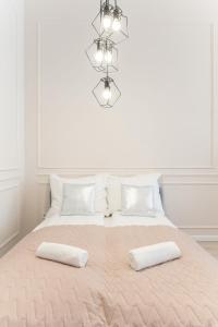 a white bedroom with a large bed with two pillows at Milano Design Apartment City Center in Budapest
