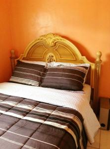 un letto con testiera decorata in una camera da letto di Alexander's Apartments a Providenciales