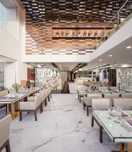 甘德希罕Ramada by Wyndham Gandhidham Shinay的一间带桌椅的餐厅和一间餐厅
