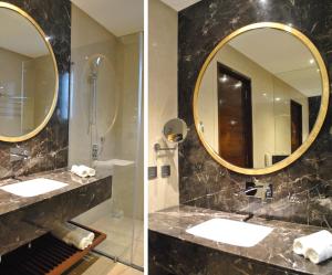 uma casa de banho com 2 lavatórios e um espelho em Ramada by Wyndham Gandhidham Shinay em Gandhidham