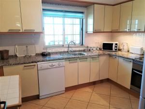 a kitchen with white cabinets and a sink at Moradia Townhouse S Sebastião F in Guia