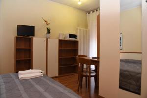 a small room with a bed and a desk and a bedroom at Residence Al Bacareto in Mogliano Veneto