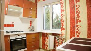 cocina con fogones y ventana en Doba In Ua Yavornitskoho6 Apartments, en Dnipro