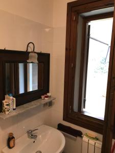 baño con lavabo, espejo y ventana en Val di Luce - Delizioso appartamento 6 posti letto - Accesso diretto alle piste da sci, en Abetone