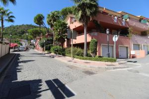 a street with palm trees and a building at Benahavis Penthouse Apartment in Benahavís