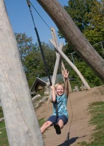 een jonge jongen schommelt op een speelplaats bij Camping het Wieskamp in Henxel