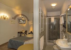 sypialnia z łóżkiem i umywalką oraz łazienka w obiekcie Il Mattino Ha L'Oro In Bocca w Pizie