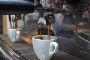 a coffee machine pouring coffee into a coffee cup at Banbury Hill Farm Bed & Breakfast in Charlbury