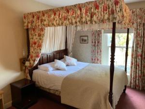 1 dormitorio con cama con dosel y ventana en Waterford Lodge Hotel, en Morpeth