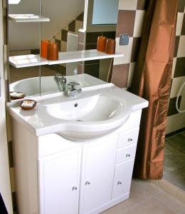 uma casa de banho com um lavatório branco e um espelho. em Hotel Cap Sud em Saint-Pierre