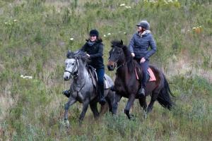 dos personas montando a caballo en un campo en Oudebosch Guest Farm en Riversdale
