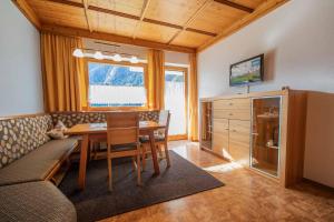 ein Esszimmer mit einem Tisch und einem Sofa in der Unterkunft Haus Larcher in Neustift im Stubaital