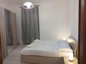 a white bedroom with a bed and a mirror at RIVERSIDE DA PO 9 Appartamenti ai piedi della collina e vicino al Po in Turin