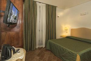 a hotel room with a bed and a flat screen tv at Il Mattino Ha L'Oro In Bocca in Pisa