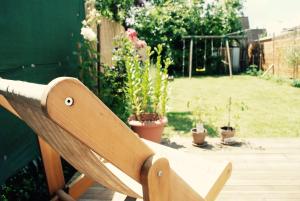 a wooden bench in a garden with potted plants at Chbre 2P + navette CDG in Aulnay-sous-Bois