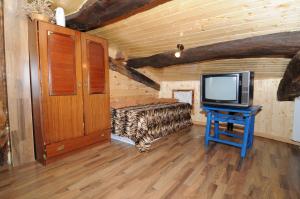 a room with a bed and a tv in a log cabin at La Resbalina Casa Rural in Cabeza del Caballo