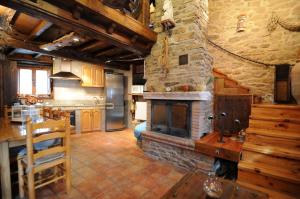 cocina con chimenea de piedra en una habitación en La Resbalina Casa Rural, en Cabeza del Caballo