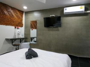 um quarto com uma cama e uma televisão na parede em Hoft Hotel em Bangkok