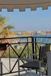 a chair on a balcony with a view of the ocean at Hotel Medusa in Lampedusa