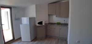 a small kitchen with a refrigerator and a window at Casa Javi y Carmen 2 DE in Coto Ríos