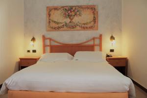 a bedroom with a large white bed with two night stands at Hotel Medusa in Lampedusa