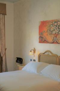 a bedroom with a bed and a painting on the wall at Hotel Medusa in Lampedusa