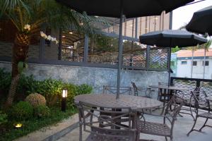a patio area with tables, chairs and umbrellas at Nohotel Nova Odessa in Nova Odessa