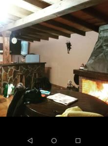 ein Wohnzimmer mit einem Tisch und einem Kamin in der Unterkunft Casa Penelas in Petín