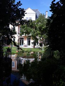 une maison se reflète dans une flaque d'eau dans l'établissement Chambres Rue De Lorry, à Bagnères-de-Bigorre