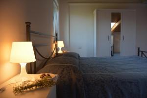 a bedroom with a bed and a table with a lamp at Casale Dionisia, Santa Maria di Castellabate, Appartamento Iris in Castellabate