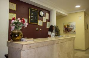 a woman is standing at a counter in a salon at His Majesty's Hotel and Apartments in Accra