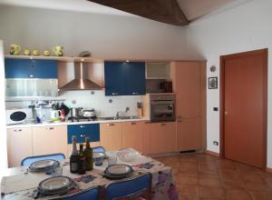 a kitchen with blue cabinets and a table with wine bottles at House Mare e Monti by Holiday World in Albenga